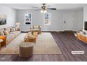 Bright, virtually staged living room with hardwood floors and large windows at 204 Colonial Dr, Clayton, NC 27527