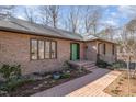 Close-up of a well-maintained brick home with a bright green front door and neatly landscaped walkway at 221 Saddle Ridge Rd, Chapel Hill, NC 27514