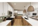 Modern kitchen featuring white and wood cabinets, stainless steel appliances, and stylish pendant lighting at 3930 Willow Gate Way, Raleigh, NC 27604