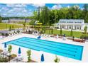 Large community swimming pool with lane markers, lounge chairs, umbrellas, and a playground nearby at 500 Trilith Pl, Durham, NC 27713