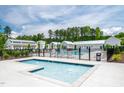 Community pool with seating areas, sun umbrellas, and a clubhouse in a beautifully landscaped setting at 500 Trilith Pl, Durham, NC 27713