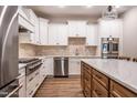 Well-lit kitchen with stainless steel appliances, white upper cabinets, and wooden lower cabinets at 525 Sanctuary Trl, Cameron, NC 28326