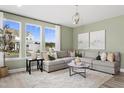 Inviting living room features a comfortable sectional sofa, stylish decor, and ample natural light from large windows at 603 Leland Hl Cir, Zebulon, NC 27597
