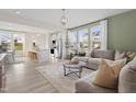 Open-concept living space with modern furnishings, flowing into a bright kitchen with an island and bar stools at 603 Leland Hl Cir, Zebulon, NC 27597