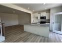 Bright, open kitchen with white cabinets, stainless appliances, and view to living area at 605 Leland Hl Cir, Zebulon, NC 27597