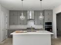 Kitchen featuring grey cabinets, stone countertops, and pendant lighting at 63 Daybreak Way, Fuquay Varina, NC 27526