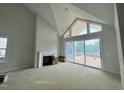 Bright living room with fireplace, large windows, and vaulted ceiling at 63 Daybreak Way, Fuquay Varina, NC 27526