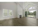 Bright and airy living room with fireplace, large windows, and sliding glass doors to the patio at 63 Daybreak Way, Fuquay Varina, NC 27526