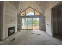Spacious living room featuring a fireplace and expansive windows showcasing the outdoor view at 63 Daybreak Way, Fuquay Varina, NC 27526