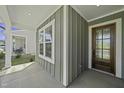 Inviting covered porch with decorative glass door and neutral siding, perfect for relaxing outdoors at 63 Daybreak Way, Fuquay Varina, NC 27526