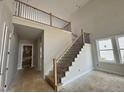 Elegant staircase with wood and iron railing leading to a loft area at 63 Daybreak Way, Fuquay Varina, NC 27526