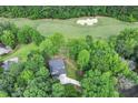 An aerial view of the home surrounded by trees and adjacent to a golf course with sand traps at 632 Angus Ct, Sanford, NC 27332