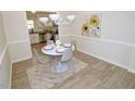 Bright dining area featuring a white table, modern chandelier, and wood-look flooring at 6525 New Market Way, Raleigh, NC 27615