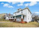 Classic two-story home with a welcoming front porch, enhanced by brick pillars and a well-maintained lawn at 802 N Elizabeth St, Durham, NC 27701
