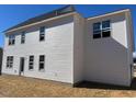The back exterior features white siding, multiple windows and a door leading to the backyard at 81 Reece Dr, Sanford, NC 27332