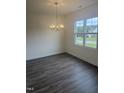 Bright dining area with hardwood floors, a modern chandelier, and a large window at 81 Reece Dr, Sanford, NC 27332
