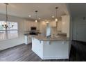 Open kitchen with breakfast bar, granite counters, stainless appliances, and stylish pendant lights at 81 Reece Dr, Sanford, NC 27332