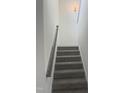 Carpeted stairway with wooden handrail offers an elegant transition between floors at 81 Reece Dr, Sanford, NC 27332