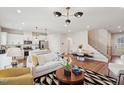 Open-concept living space featuring hardwood floors, stylish furniture, and a modern staircase at 917 Montague Ave, Durham, NC 27703
