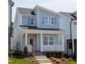 Beautiful two-story home with light blue exterior, white porch, and stylish landscaping at 928 Allen Park Dr, Knightdale, NC 27604