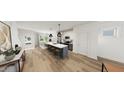 Open-concept kitchen featuring a large island with bar seating, stainless steel appliances, and modern pendant lighting at 928 Allen Park Dr, Knightdale, NC 27604
