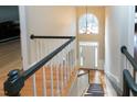 Bright foyer features hardwood floors, staircase with black railing, and a large arched window at 100 Burlingame Way, Cary, NC 27513
