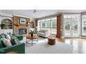 Bright living room with stone fireplace, built-in shelves, large windows, and hardwood floors at 100 Burlingame Way, Cary, NC 27513