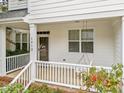 Cozy covered porch featuring a swing, white railings, and inviting front entrance at 1012 Palace Garden Way, Raleigh, NC 27603