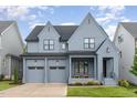 Charming two-story home showcasing a modern design, neat landscaping, and a welcoming front porch with seating at 183 Post Oak Rd, Chapel Hill, NC 27516