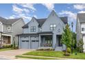 Beautiful, two-story home featuring gray siding, black trim, two-car garage, and charming front porch at 183 Post Oak Rd, Chapel Hill, NC 27516