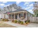 Beautiful home featuring a welcoming front porch, rocking chairs, swing, and lovely landscaping at 202 W Hill St, Benson, NC 27504