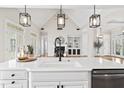 Open-concept kitchen with white countertops, a modern faucet, and seamless views into the bright, airy living space at 2021 Rockwall Farms Ln, Fuquay Varina, NC 27526