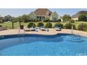 Sparkling in-ground pool with sun loungers, enveloped by a secure fence, creating a perfect backyard oasis at 2021 Rockwall Farms Ln, Fuquay Varina, NC 27526
