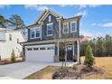 Attractive two-story home featuring blue siding, a two-car garage, and well-maintained landscaping at 2515 Maplemere Ct, Durham, NC 27703