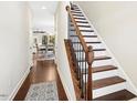 Elegant hallway featuring wood floors, staircase with iron spindles, and views into the dining area at 2515 Maplemere Ct, Durham, NC 27703