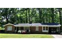 Lovely brick home with a covered carport, accented by colorful flowers and a well-maintained lawn at 323 Ranch Farm Rd, Raleigh, NC 27603