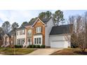 Charming home showcasing a two-car garage and brick facade, set amidst lush greenery at 3528 Dewing Dr, Raleigh, NC 27616