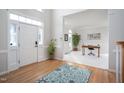 Bright foyer with hardwood floors, a patterned rug, and view to an office with a large desk at 3528 Dewing Dr, Raleigh, NC 27616