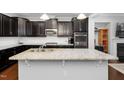 Modern kitchen featuring granite countertops, dark cabinets, stainless steel appliances, and a spacious island at 357 Roberts Ridge Dr, Cary, NC 27513