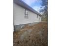 Side view of home with white siding and trim; small windows and concrete foundation at 4805 Barbee Rd, Durham, NC 27713