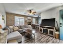 Open concept living room with brick accent wall, modern furnishings, and a view into the dining area at 4901 North Pointe, Sanford, NC 27332