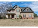 A charming two-story home featuring horizontal siding, complemented by brick accents, and a welcoming front porch at 5439 Cokesbury Rd, Fuquay Varina, NC 27526