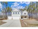 Two-story home with gray siding, stone accents, three-car garage, and landscaping with green trees surrounding the property at 6800 Franklin Heights Rd, Cary, NC 27518