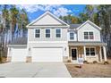 Two-story home with gray siding, stone accents, three-car garage, landscaping, and a 'For Sale' sign at 6800 Franklin Heights Rd, Cary, NC 27518