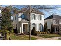 Charming two-story home with painted brick exterior, shutters, mature trees, and brick walkway at 809 Wayne Dr, Raleigh, NC 27608