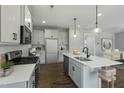 This modern kitchen features sleek white cabinets, stainless steel appliances, an island and pendant lighting at 73 Merle Dr, Wendell, NC 27591