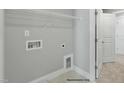 Practical laundry room with shelving, utility connections, and a nearby door for easy access at 54 Merle Dr, Wendell, NC 27591