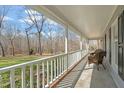 Spacious covered front porch with views of the landscaped yard and surrounding trees at 11424 Horsemans Trl, Raleigh, NC 27613