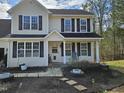 Close-up of a charming two-story home showcasing the welcoming front porch at 1201 Teakwood Ct, Sanford, NC 27330