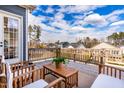 Relaxing back deck with wood furniture, offering stunning views of the surrounding neighborhood and lush greenery at 124 Ferrell W Rd, Apex, NC 27523